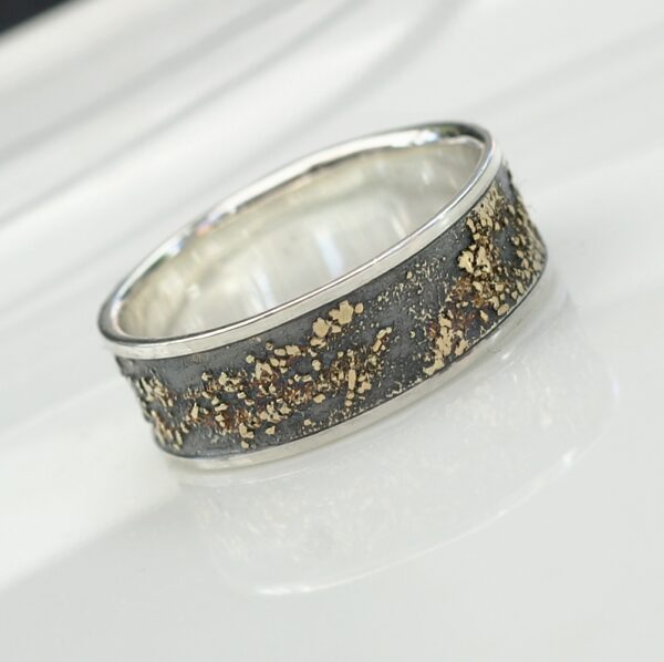 Gold Chaos with Silver Edges: The ring is made of sterling silver, slightly textured with reticulation and oxidized. Gold spots are solid 18kt gold. It is random mix of gold dust, microgranules and solder fused to silver surface. The edge is solid 18k gold.